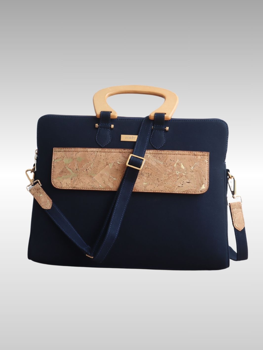 Woman carrying FOReT® Navy Blue Laptop Bag in canvas and FSC-certified cork with gold-flecked details – ethical luxury fashion
